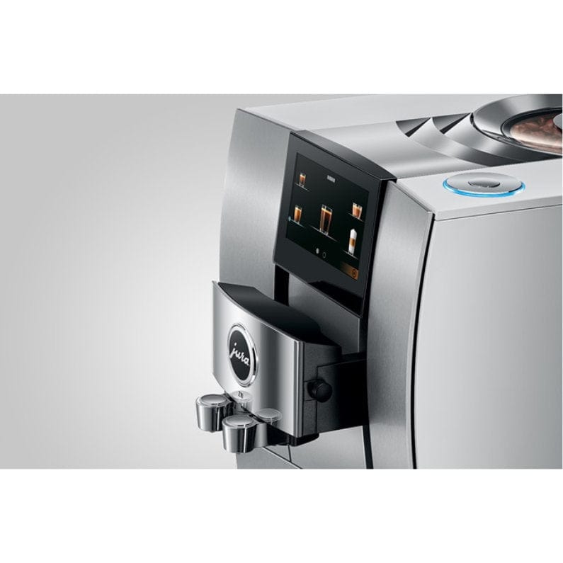 A close-up of the Jura Z10 Aluminum White Super Automatic Hot Coffee & Espresso, Cold Brew, & Specialty Beverage Machine 15361 by Jura highlights its modern silver finish, digital display, dual spouts, and a circular button on top. This advanced machine features a Product Recognising Grinder for optimal coffee quality.