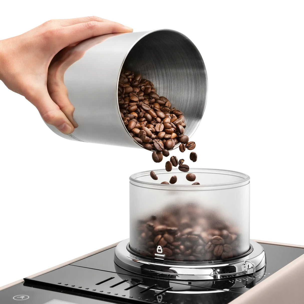 A hand pours coffee beans from a metal container into the bean hopper of the De’Longhi Rivelia Super Automatic Espresso Machine EXAM44055BG (Sand Beige) by DeLonghi, featuring the innovative Bean Switch System for easy flavor changes.