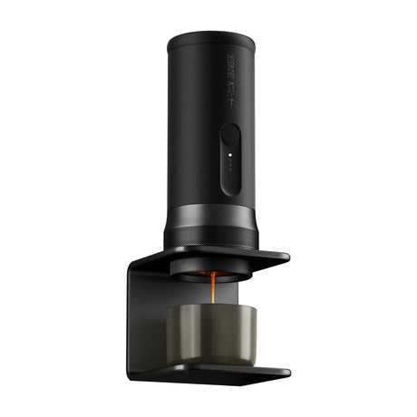 The MHW-3BOMBER Espresso Ready Travel Kit Bundle dispenses espresso into a gray cup on a sleek black wall-mounted holder—perfect for a modern home setup.