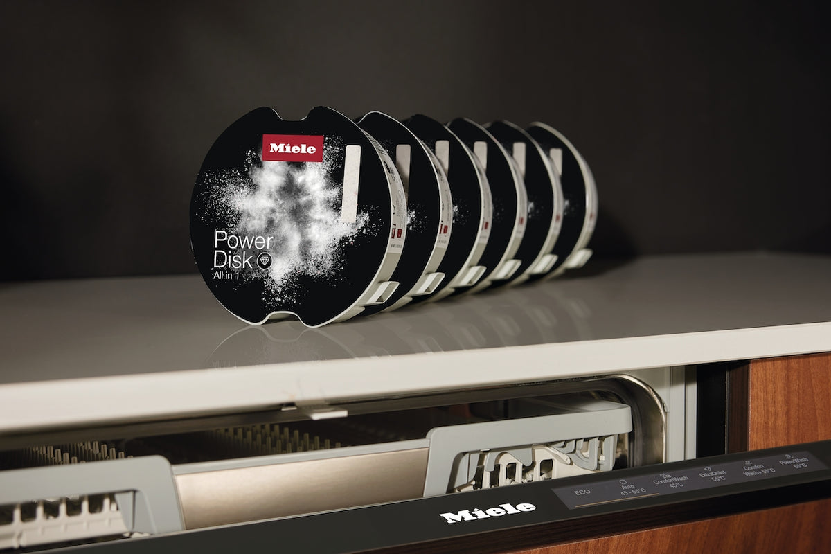Miele PowerDisk All in 1 disks beside an AutoDos dishwasher