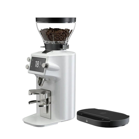 The Mahlkönig E64 WS Espresso Home Grinder in white, featuring a digital display and filled with beans, stands beside a black digital scale on a white background—perfect for brewing café-quality espresso at home.