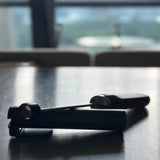 A Subminimal V2 NanoFoamer (Black) by Subminimal rests on a reflective kitchen countertop, ready to help you create silky microfoam for artistic lattes.