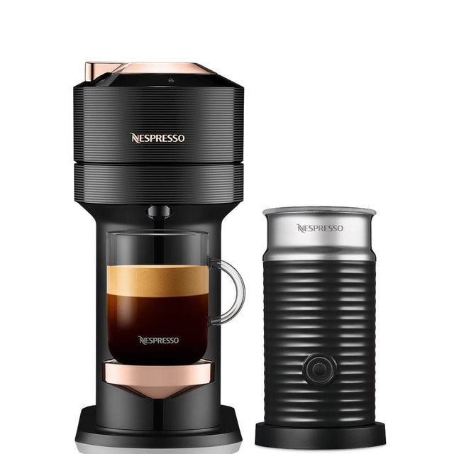 A Nespresso Vertuo Next Premium Coffee and Espresso Machine with Aeroccino by De'Longhi ENV120BAE (Black with Rose Gold) featuring Automatic Blend Recognition and a glass cup of Nespresso coffee in the holder. The sleek design boasts rose gold accents and "Nespresso" branding. Beside it, a matching black ribbed milk frother from De'Longhi features the same branding, ensuring a cohesive look.