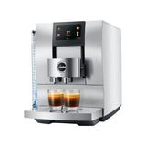 Sure! Here’s a revised version of your sentence using the provided product data: The Jura Z10 Aluminum White Super Automatic Hot Coffee & Espresso, Cold Brew, & Specialty Beverage Machine (model 15361) features a sleek modern silver design with a digital display and the Jura logo displayed prominently on the front. It can prepare two cups of coffee simultaneously and includes an advanced Product Recognising Grinder for precise coffee preparation.