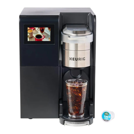 A Keurig K3550 K-Cup® Commercial Brewing System from Keurig brews an iced drink into a clear cup of ice. An Iced Coffee K-Cup pod is nearby, and the display features an image of coffee cups.