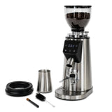 The Bellucci Preciso Mini Coffee Grinder (Stainless Steel) by Bellucci features a digital display, 64mm flat burrs, and comes with a metal container, black lid, cleaning brush, and scoop—ideal for home espresso.