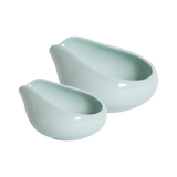 Two celadon blue, glossy ceramic trays with rounded shapes and wide, slanted openings from Loveramics are placed side by side on a white background. Reminiscent of a refined porcelain coffee accessory featured by James Hoffmann, the Loveramics Coffee Dosing Tray Set of 2 showcases one larger and one smaller tray appearing neatly nested together.