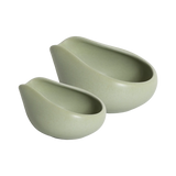 Two matte light green Loveramics Coffee Dosing Trays, crafted in smooth ceramic with curved, asymmetrical edges and a clean, modern aesthetic, nest side by side on a white background.