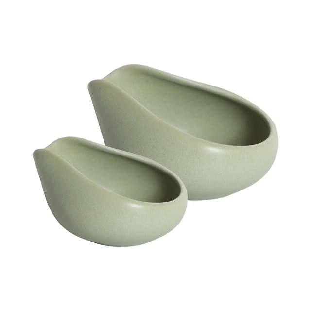 Two matte light green Loveramics Coffee Dosing Trays, crafted in smooth ceramic with curved, asymmetrical edges and a clean, modern aesthetic, nest side by side on a white background.
