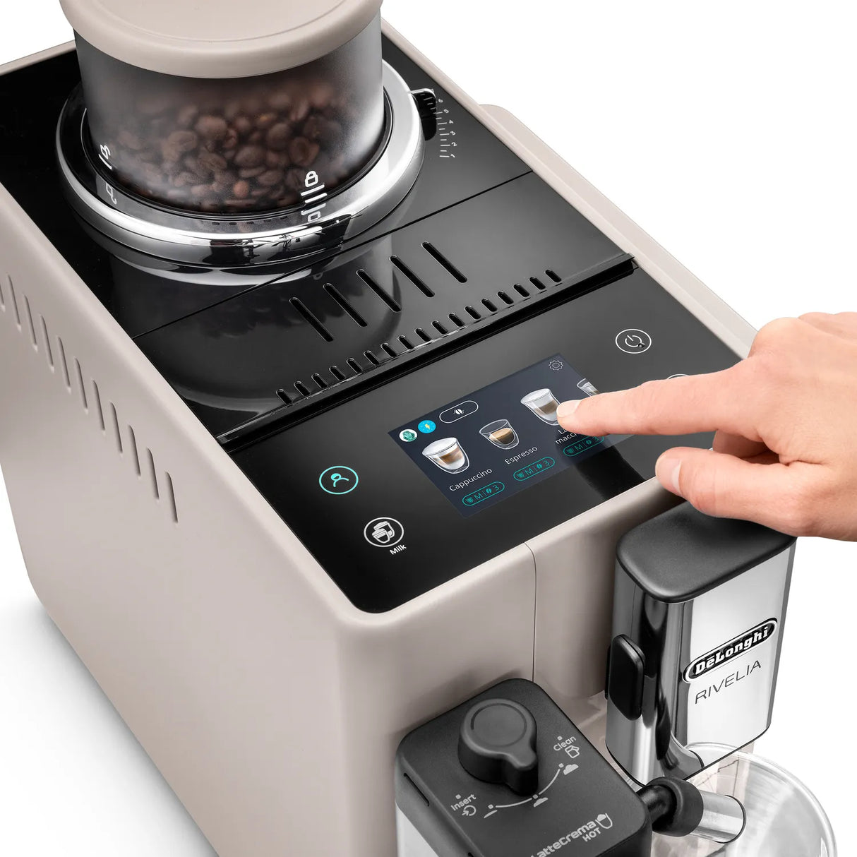 A hand presses a button on the DeLonghi Rivelia Super Automatic Espresso Machine EXAM44055BG (Sand Beige) digital display, next to the innovative Bean Switch System coffee bean hopper and the LatteCrema Hot Technology milk frother attachment.