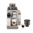 A DeLonghi Rivelia Super Automatic Espresso Machine EXAM44055BG in Sand Beige, equipped with LatteCrema Hot Technology and a milk frother, is displayed on a white background alongside a glass of cappuccino, an espresso, and two coffee bean containers featuring the Bean Switch System.