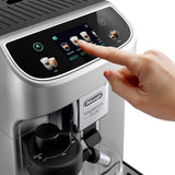 A hand selects cappuccino on the touchscreen of the DeLonghi Magnifica Plus Super Automatic Espresso Machine with LatteCrema System ECAM32070SB, as a cup waits below for a fresh, delicious coffee drink.
