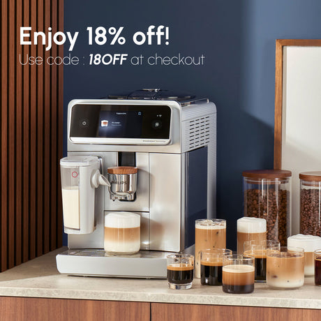 A Philips Cafe Aromis 8000 Super Automatic Espresso Machine with LatteGo Pro EP8757/20 (Stainless Steel) by Philips sits on a counter beside several cups of coffee and jars of coffee beans. Text reads: “Enjoy 18% off! Use code: 18OFF at checkout.”.