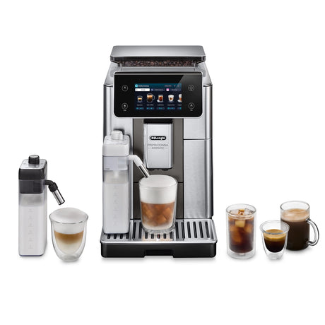 The DeLonghi PrimaDonna Aromatic Super Automatic Espresso Machine ECAM63075TM, with a digital display and Bean Adapt technology, is shown with glasses of espresso, cappuccino, latte, iced coffee, cold foam, and two milk frothers on the sides.