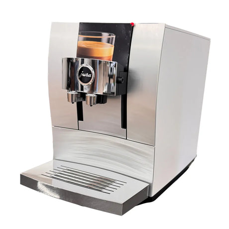 A Jura Z10 Aluminum White Super Automatic Hot Coffee & Espresso, Cold Brew, & Specialty Beverage Machine (model 15361) from Jura dispenses a cup of coffee, with a small glass of espresso positioned on its central shelf beneath the dual spouts—enhanced by its innovative Product Recognizing Grinder for the perfect brew every time.