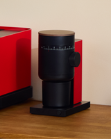 Fellow Opus 2 Conical Burr Grinder in cherry red with walnut lid, angled view