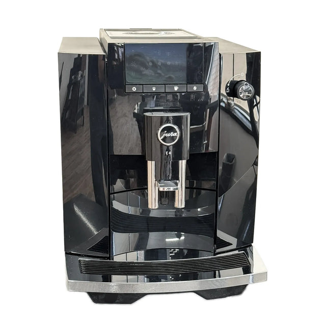 A Jura E4 Super Automatic Coffee Machine 15466 in Piano Black by Jura, featuring a digital display, dual spouts, and the innovative Pulse Extraction Process (P.E.P.), is shown on a white background.