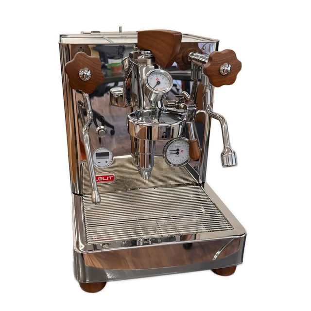 The Lelit Bianca 3 Semi-Automatic Dual-Boiler E61 Espresso Machine with PID PL162T (Version 3) - Returned (4607), crafted by Lelit, is an Italian-made stainless steel espresso machine featuring elegant wooden handles, precise pressure gauges, and a professional steam wand. This premium home coffee maker sits atop a reflective surface with its drip tray neatly positioned beneath the spout.