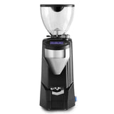 The Rocket Fausto 2.1 Espresso Macinatore Coffee Grinder RG821A3A12 (Black) is a sleek grinder that boasts a transparent bean hopper on top. It features a digital touch display panel complemented by buttons below it and a metallic dispensing chute at the front. The modern, compact design of this Rocket coffee grinder makes it perfect for both home and professional use, embodying the excellence associated with Rocket Espresso Machines.