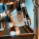 Close-up of the ECM Technika VI Dual Boiler Espresso Machine with ECM branding; features include portafilters, metal accents, and PID temperature control.