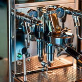 A close-up of the ECM Technika VI Dual Boiler Espresso Machine w/ PID shows its stainless steel body, multiple gauges, levers, and portafilter. The digital display is on, reading 93°C with precise PID temperature control.