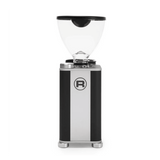 The Rocket Giannino Coffee Grinder R01RG099B3A12 by Rocket features a transparent bean hopper, black-stainless steel rectangular body, micrometric grind adjustment, and a circular "R" logo on the front, shown against a white background with a green border.