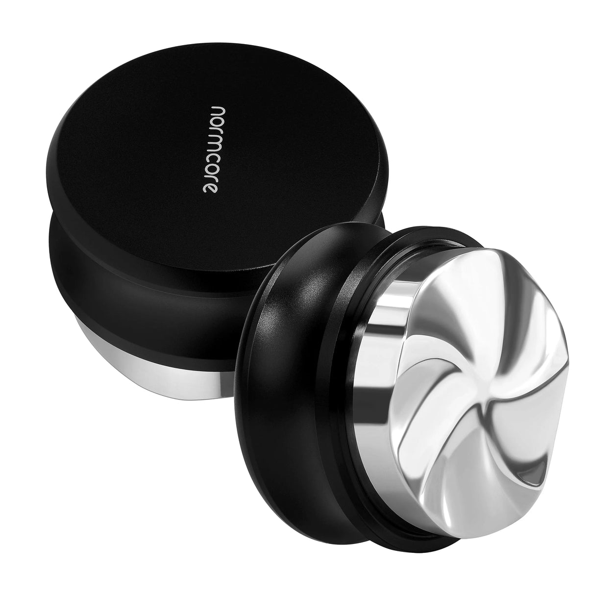 Two Normcore Gravity Distributor Tools (58.5mm) with black handles and stainless steel bases—one laying flat, the other tilted to reveal the grooved distribution surface. Expertly crafted by Normcore as a precision portafilter accessory, these gravity coffee distributors ensure perfectly even tamping for consistently excellent espresso shots every time.