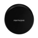 A black, round Normcore Gravity Distributor Tool (58.5mm) with "normcore" in white lowercase letters on top, seen from above against a white background. Perfectly sized to fit a 58.5mm portafilter, this tool by Normcore ensures even coffee grounds distribution for consistent espresso extraction.