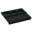 The Normcore Espresso Corner Tamping Station V3 by Normcore is a black rectangular desk organizer featuring three round compartments and a narrow slot, crafted with non-slip silicone for enhanced stability. Perfect for holding small items such as coins, keys, or pens, its versatile design is also compatible with portafilters—making it an ideal espresso tamping station.