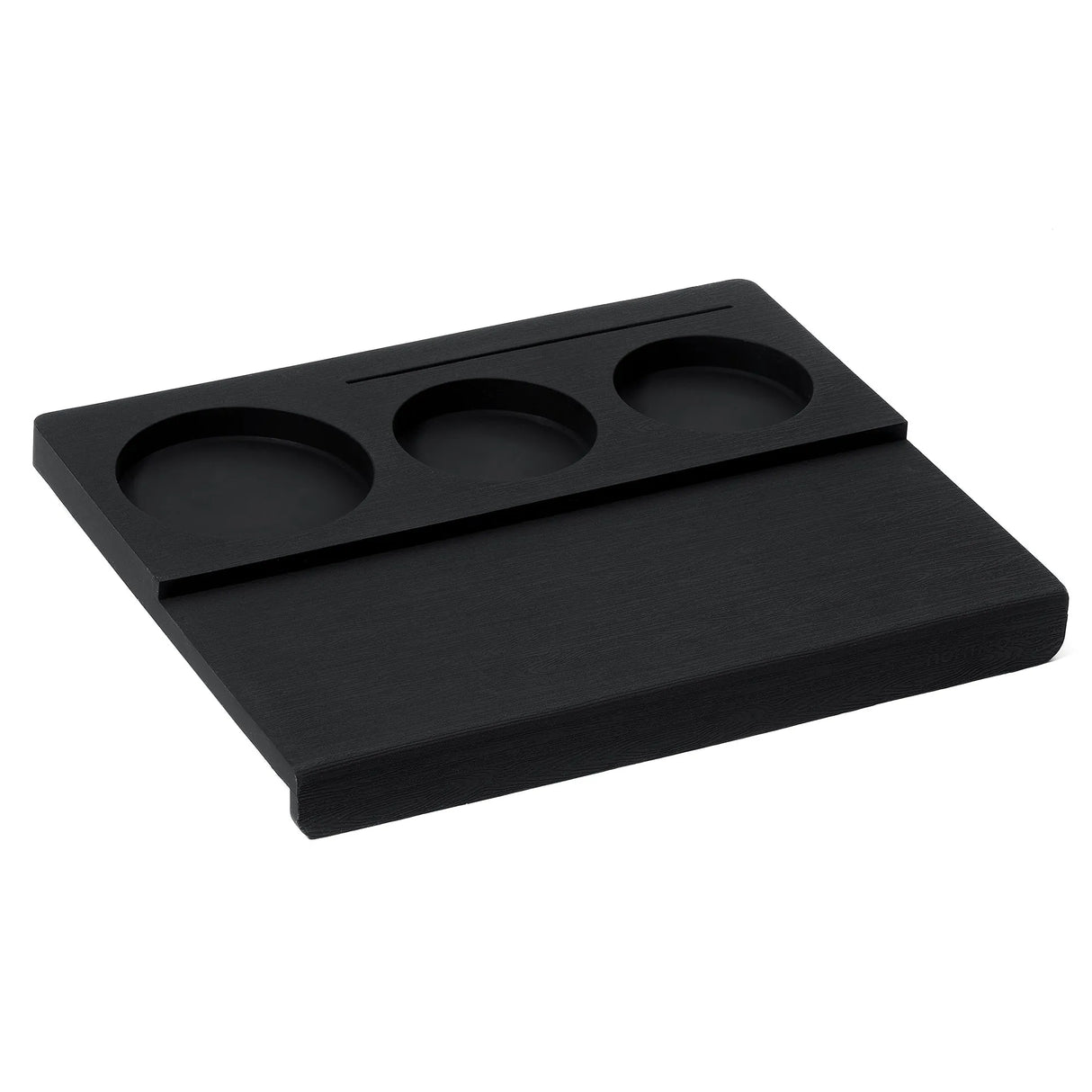 The Normcore Espresso Corner Tamping Station V3 by Normcore is a black rectangular desk organizer featuring three round compartments and a narrow slot, crafted with non-slip silicone for enhanced stability. Perfect for holding small items such as coins, keys, or pens, its versatile design is also compatible with portafilters—making it an ideal espresso tamping station.