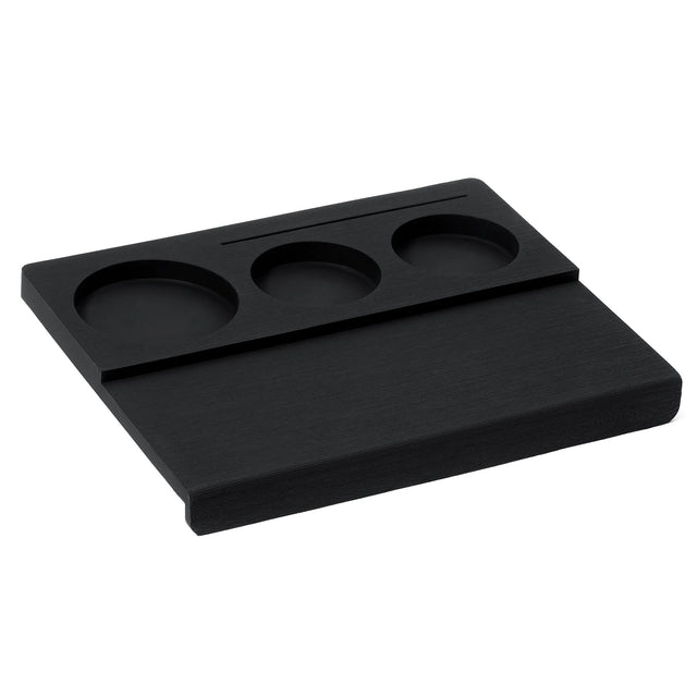 The Normcore Espresso Corner Tamping Station V3 by Normcore is a black rectangular desk organizer featuring three round compartments and a narrow slot, crafted with non-slip silicone for enhanced stability. Perfect for holding small items such as coins, keys, or pens, its versatile design is also compatible with portafilters—making it an ideal espresso tamping station.