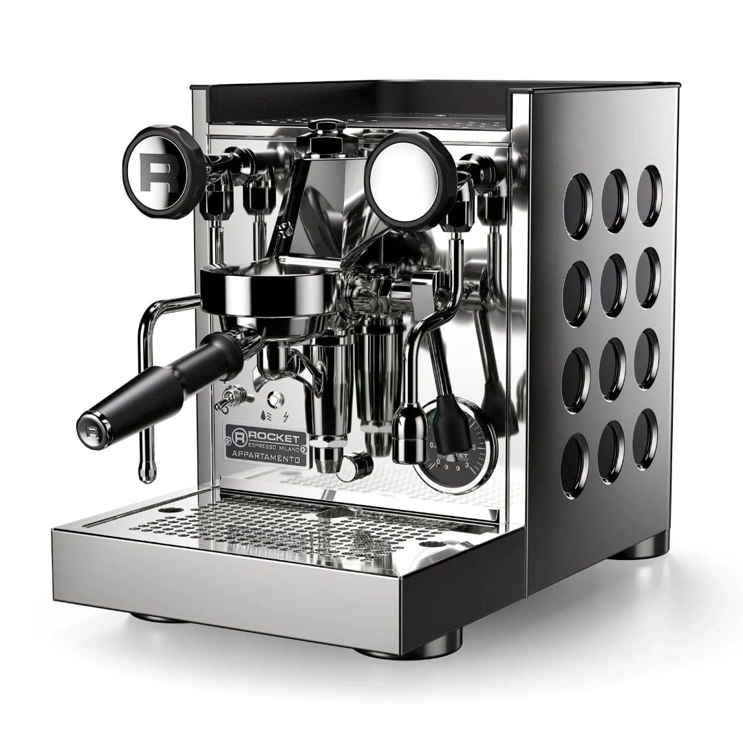 The Rocket Appartamento TCA Espresso Machine RE502A3B12 is a sleek, stainless steel premium domestic espresso machine with a modern design. It features a portafilter, pressure gauges, multiple adjustment knobs, and Temperature Control Adjustment. The "Rocket" brand logo is prominently displayed on the front of the Appartamento TCA, and circular cut-out patterns elegantly adorn the sides.