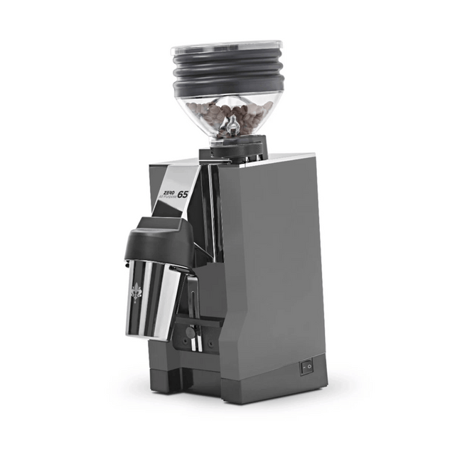 A grey Eureka Mignon Zero 65 All Purpose Grinder by Eureka, shown on a plain white background with a clear hopper of coffee beans. This model is currently backordered.