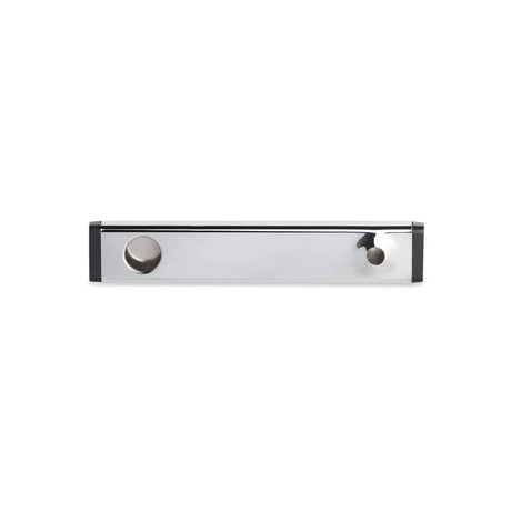A sleek, rectangular, metallic kitchen sink caddy with a brushed stainless steel finish reminiscent of the Moccamaster 1-Hole Outlet Arm 53054 and black plastic ends. The caddy features a round hole on the left side for a soap bottle and a smaller hole on the right side for a sponge or brush.