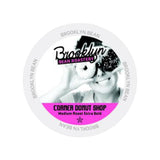 A circular coffee pod label features a grayscale image of a person with donuts in front of their eyes. The text reads, "Brooklyn Bean Roastery" and "Corner Donut Shop Medium Roast Extra Bold." Ideal for your Keurig K-Cup, the label also has "Brooklyn Bean" repeated around the edge. This design is from Brooklyn Bean Corner Donut Shop Extra Bold Single-Serve Coffee Pods (Case of 160).