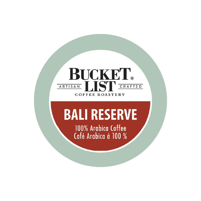 The label for Bucket List's Bali Reserve Single Serve Pods, sold in boxes of 24, features a circular design with a green outer ring and a white inner circle. The text inside reads "BUCKET LIST ARTISAN CRAFTED" at the top, accompanied by the logo, and "COFFEE ROASTERY" below. The red center text highlights "BALI RESERVE 100% Arabica Coffee Café Arabica à 100%," indicating that these single-serve pods are Keurig compatible.