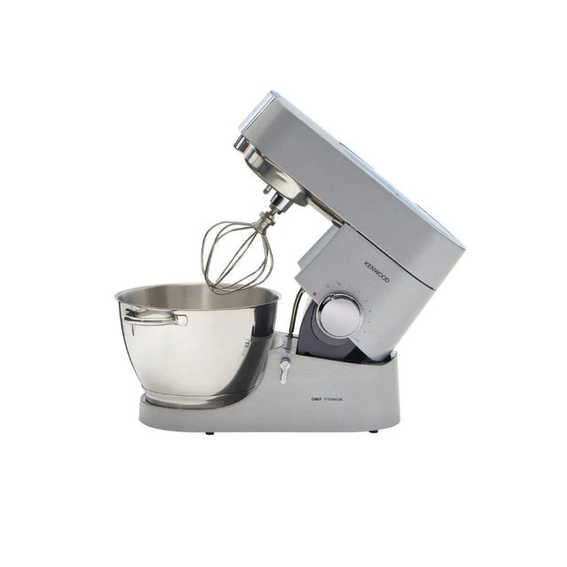 The Kenwood Chef Titanium KMC011 Stand Mixer & Kitchen Machine (4.7L / 5.0QT) features a powerful 720 Watt motor, a stainless steel mixing bowl, and a wire whisk attachment. The sleek silver stainless steel mixer is tilted back to display its mechanism and controls, boasting a modern aesthetic with the Kenwood brand logo prominently on the side and expandable attachments available.