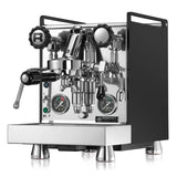 A sleek, modern black and silver espresso machine featuring various knobs, levers, and pressure gauges on the front. Branded as the Rocket Mozzafiato Cronometro Type R Espresso Machine w/ PID Temperature Control RE851E3B11 (Black), it prominently displays an "R" logo and is equipped with PID temperature control for precise brewing.