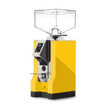 The Eureka Mignon Specialita, a yellow coffee grinder from Eureka, features a clear square hopper on top, a digital display on the front, and a black dispensing chute. It boasts near silent operation and has a modern, sleek design.