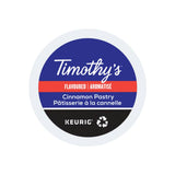 A Timothy's Cinnamon Pastry K-Cup® Recyclable Pod is pictured. The pod, bearing the brand name "Timothy's," features a blue and red label with text reading "Timothy's Flavoured Cinnamon Pastry Pâtisserie à la cannelle" and a recycling symbol at the bottom, perfect for cinnamon coffee lovers seeking a medium roast delight.