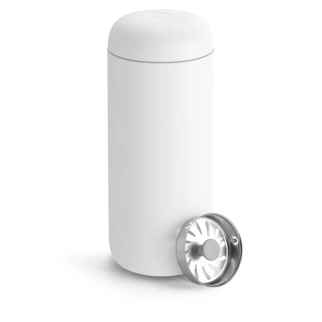 The Fellow Carter Move Mug 16oz (Matte White) by Fellow is a sleek, cylindrical white travel mug with a detachable front lid. The lid features a polished metal interior with a circular pattern of vents, while the minimalist-designed thermos boasts a smooth surface and an elegant ceramic interior for an elevated drinking experience.