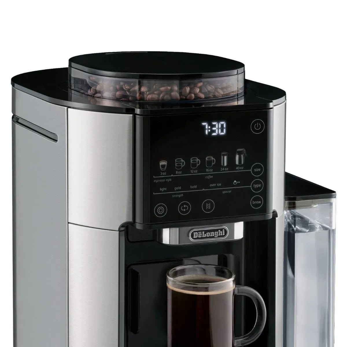 The DeLonghi TrueBrew Fully Automatic Drip Coffee Machine CAM51035M in stainless steel with a thermal carafe features a digital display showing 7:30. The control panel includes buttons for various coffee types and strength settings. A transparent water reservoir is on the right side, and a mug of single-serve drip coffee is positioned beneath the dispenser.